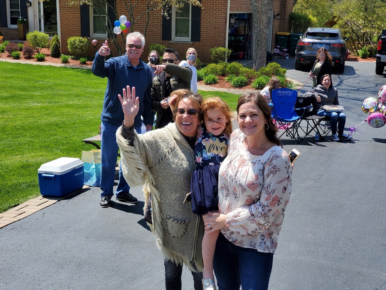 The Krumwiede family waves as people drive by for Peyton’s birthday